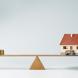 Maison miniature en équilibre sur une planche en bois