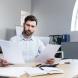 Un professionnel de l'immobilier entouré de documents 
