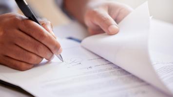 homme qui signe un document