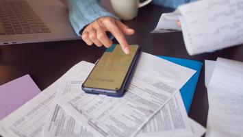Gros plan sur une femme comptant les factures sur une calculatrice