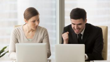 Le méchant perdant de l'employé regarde avec enthousiasme le gagnant promu qui profite du succès