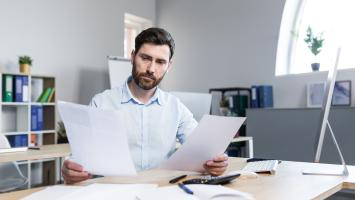Un professionnel de l'immobilier entouré de documents 