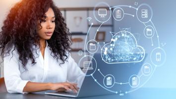 Femme d'affaires travaillant sur son ordinateur portable avec des hologrammes liés à la cybersécurité
