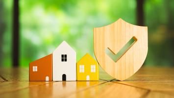 Des maisons miniatures colorées en bois et un bouclier