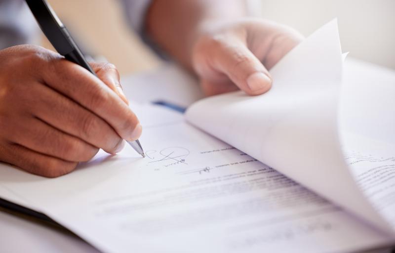 homme qui signe un document