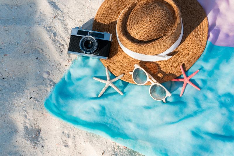 Des accessoires pour l'été posés sur une serviette de plage
