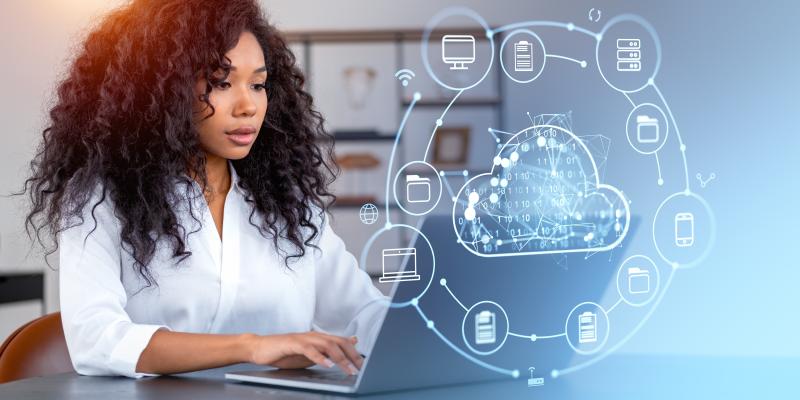 Femme d'affaires travaillant sur son ordinateur portable avec des hologrammes liés à la cybersécurité