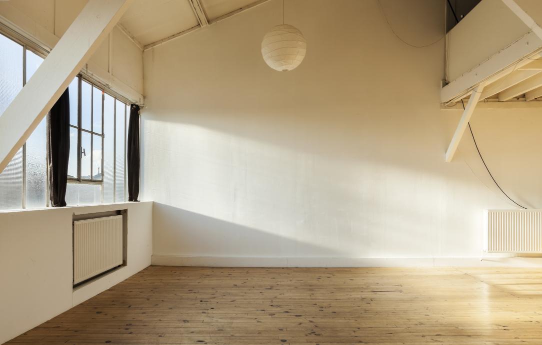 L'intérieur d'un appartement vide aux murs blancs et baigné de soleil