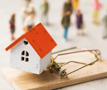 Une maison miniature posée sur un piège à souris
